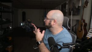 Man filming with camera in home studio setting